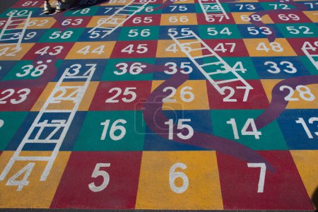 Foto de Painted hopscotch game on an asphalt road. The numbers on the classics grid are drawn on the pavement. An exciting childrens game. - Imagen libre de derechos