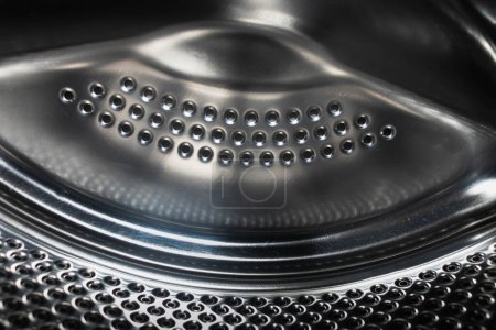 Stainless metal surface of the washing machine drum.inner metal drum of the washing machine. Inside the washing machine.