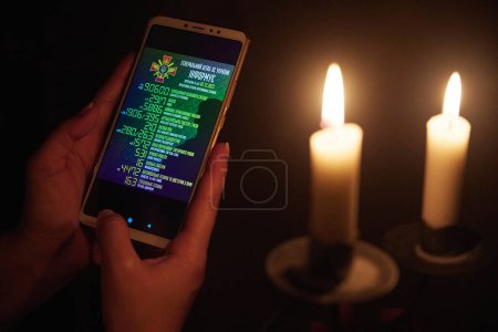 Foto de Kiev, Ucrania, diciembre de 2022: Ucrania observa información sobre las pérdidas de soldados rusos en casa sin electricidad. - Imagen libre de derechos
