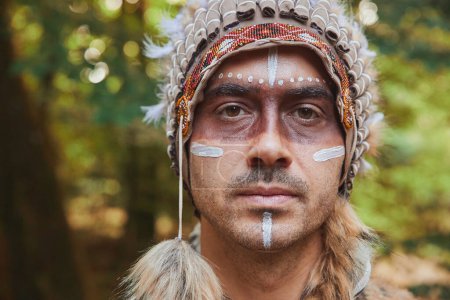 Téléchargez les photos : A man in traditional Native American clothing in the evening forest. - en image libre de droit