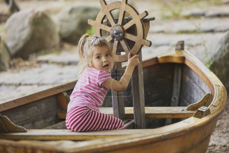 Photo for Charming child playing in a toy boat in Denmark. - Royalty Free Image