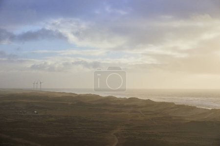 Photo for Stormy northern sea at sunset in Denmark. Windmills on the horizon. - Royalty Free Image