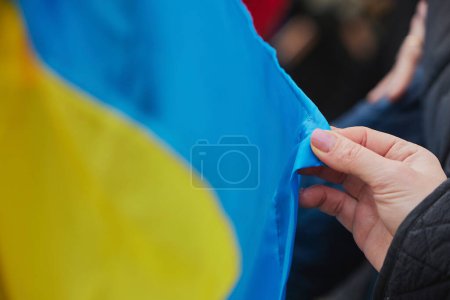 Woman holding Ukrainian flag on action in support of Ukraine in Denmark.