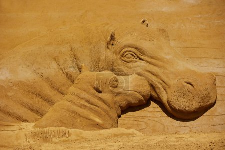 Photo for Sondervig, Denmark, May 11, 2024: International Sand Sculpture Festival. Hippopotamus with a child - Royalty Free Image