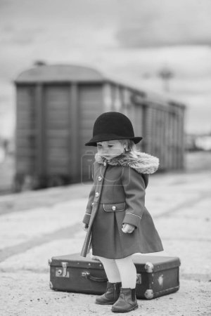 Retro-Foto eines kleinen Mädchens, das auf einen Zug wartet.