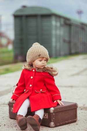 Charming baby girl who is waiting for a train.