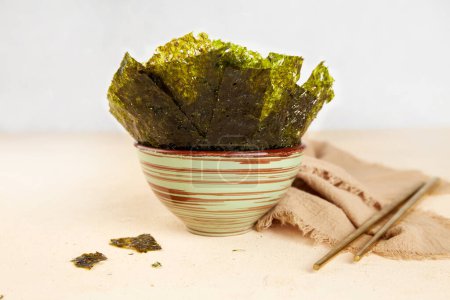 Algues nori croustillantes sur bol. Feuilles d'algues sèches japonaises traditionnelles. Collation saine 