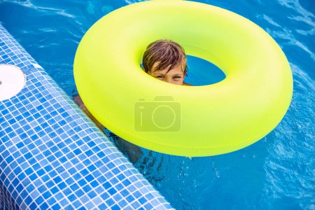 Photo for Teen boy with inflatable ring relaxing in swimming pool. Children summer fun, vacation, sunny day. Kids water sport activity on summer holiday. - Royalty Free Image