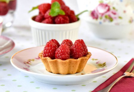 Téléchargez les photos : Mini tartes aux framboises servies avec du thé sur la table - en image libre de droit