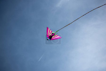 Foto de Colorido asiático cometa de seda volando contra el cielo azul - Imagen libre de derechos