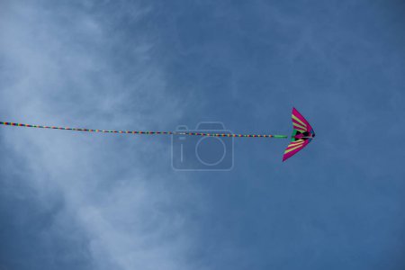 Foto de Colorido asiático cometa de seda volando contra el cielo azul - Imagen libre de derechos