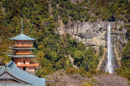 Three story pagoda of Seiganto-ji Tendai Buddhist temple in Wakayama Prefecture, Japan with Nachi Falls in the background