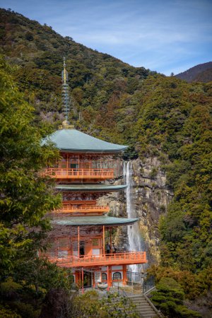 Pagode de trois étages du temple bouddhiste Seiganto-ji Tendai dans la préfecture de Wakayama, Japon avec les chutes de Nachi en arrière-plan
