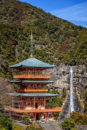 Three story pagoda of Seiganto-ji Tendai Buddhist temple in Wakayama Prefecture, Japan with Nachi Falls in the background