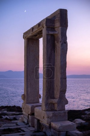 Remains of Portara gate of the Temple of Apollo at Naxos island in the Cyclades, Aegean Sea, Greece at sunset