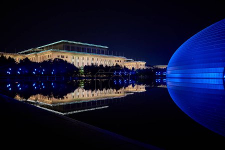 Vue de nuit du Centre national des arts de la scène NCPA avec Congrès national des peuples (Grande Salle du Peuple) en arrière-plan à Pékin, Chine, le 20 avril 2024