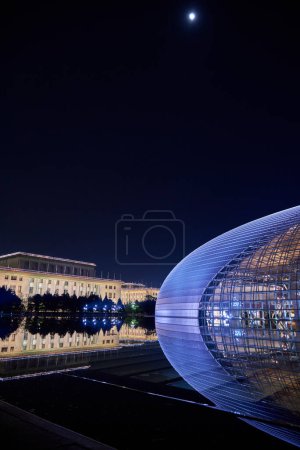 Vue de nuit du Centre national des arts de la scène NCPA avec Congrès national des peuples (Grande Salle du Peuple) en arrière-plan à Pékin, Chine, le 20 avril 2024