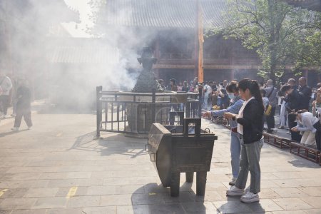 Téléchargez les photos : Personnes brûlant de l'encens et priant dans le temple Yonghe du bouddhisme tibétain dans le district de Dongcheng à Pékin, en Chine, le 21 avril 2024 - en image libre de droit