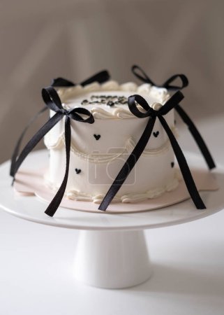 Mini gâteau d'anniversaire blanc décoré d'arcs et de c?urs noirs