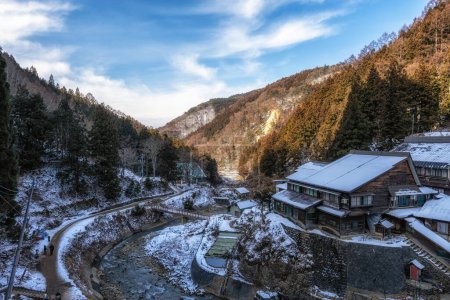 Photo for Snow covered mountain and a small ryokan view on the way to Jigokudani Monkey Park in Nagano, Japan. - Royalty Free Image