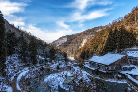 Foto de Snow covered mountain and a small ryokan view on the way to Jigokudani Monkey Park in Nagano, Japan. - Imagen libre de derechos