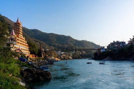 Téléchargez les photos : Rishikesh, Uttarakhand, Inde - 27.03.2023 : Centre-ville de Rishikesh avec temples de yoga et rivière claire Ganga. Photo de haute qualité - en image libre de droit