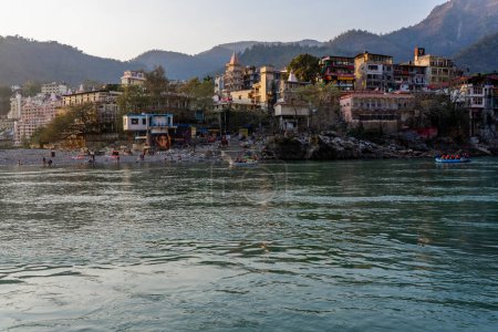 Téléchargez les photos : Rishikesh, Uttarakhand, Inde - 28.03.2023 : Belle rivière Ganga à Rishikesh entourée de ashrames et de temples. Eau pure et propre de la rivière. Photo de haute qualité - en image libre de droit