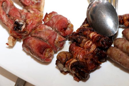 Mixed roast meat. Gnummareddi, rolls based on lamb offal, sausage and the bombette martinesi, meat rolls stuffed with cheese. High quality photo