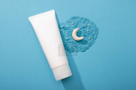 Photo for Cosmetology product for night facial care. Mockup white Cosmetic tube and plasticine modeling clay moon and stars on blue background. Skincare, moisturizing beauty, unbranded lotion, toothpaste, cream - Royalty Free Image