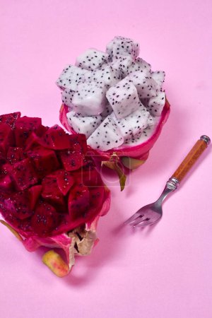 Téléchargez les photos : Fruits du dragon rouge Servir avec une portion appétissante Isolé sur fond rose. Vue du dessus, main - en image libre de droit