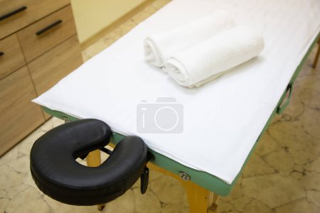 Téléchargez les photos : Table de massage professionnelle installée dans un bureau de massage et recouverte de draps blancs prêts pour un client - en image libre de droit