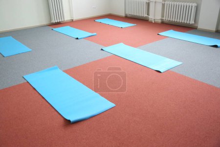Leere Sporthalle mit Matten für Yoga oder Sport