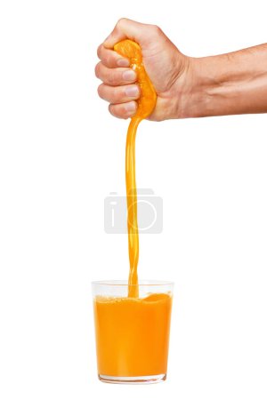 A man's hand squeezes a ripe orange into a glass. A man is holding and squeezing an orange. Orange juice is pouring. Isolated on a white background.
