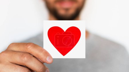 Téléchargez les photos : Man holding a red heart. Romantic man. Message. Love. The senses. - en image libre de droit