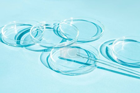 Petri dish. A set of Petri cups. A pipette, glass tube. On a blue blue background.