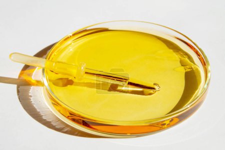 Petri dishes. With yellow liquid. With solution. Medical pipette. On a white background.