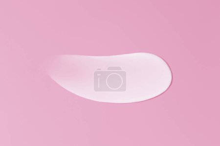 Close-up smear of cream texture on a pink background