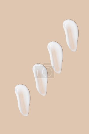 Photo for A set of strokes of white cream on a beige background. - Royalty Free Image