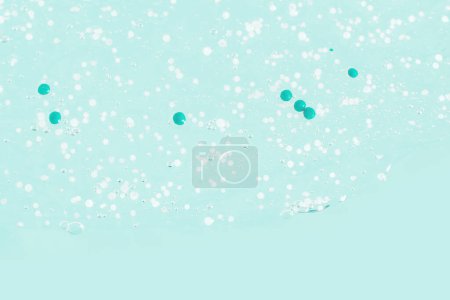 Téléchargez les photos : Gel transparent enduit de granules bleus. Sur fond vert. - en image libre de droit