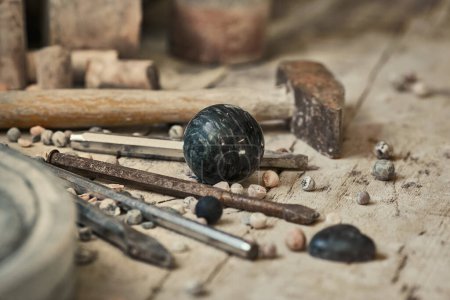 Hintergrund mit verschiedenen Werkzeugen für die Arbeit mit Stein. Steinskulpturen im Hintergrund in der Werkstatt. Handarbeit