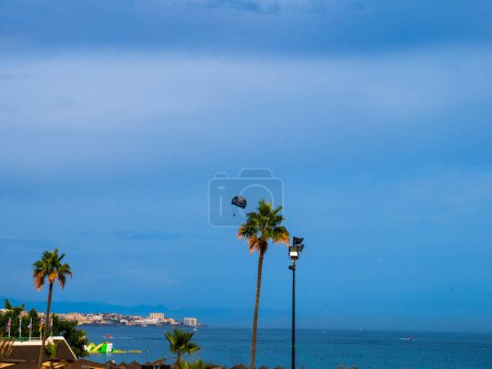 Photo for Hang Glider over Beach and  the promenade in Fuengirola on the Costa Del Sol Spain - Royalty Free Image