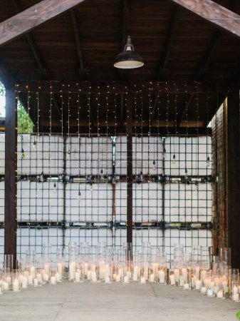 Photo for The wooden terrace is decorated with glowing garlands and lit white candles in glass candlesticks.Outdoor party. - Royalty Free Image