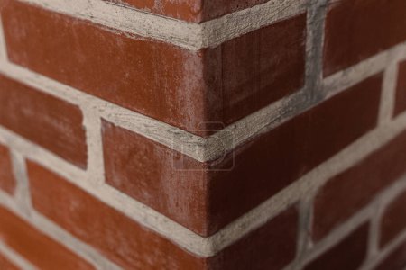 Téléchargez les photos : Un coin de mur de briques. Coin d'un mur de briques rouges avec des coutures blanches. Texture murale et briques. - en image libre de droit