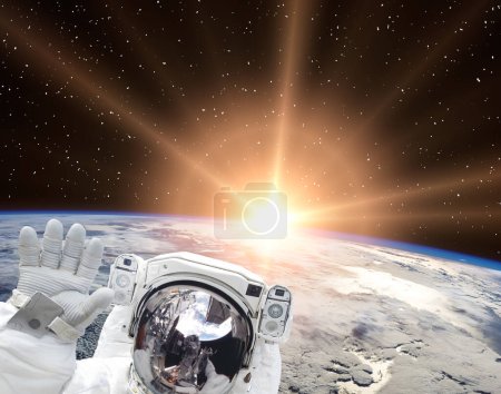 Foto de Ondas de astronauta contra el hermoso amanecer. Los elementos de esta imagen proporcionados por la NASA - Imagen libre de derechos