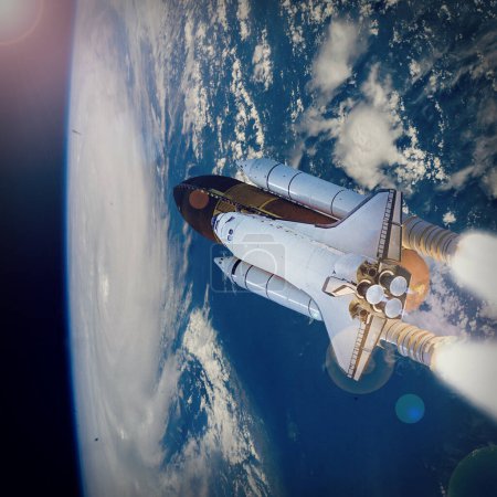 Téléchargez les photos : Fusée volant au-dessus de la terre dans l'espace. Les éléments de cette image fournis par la NASA - en image libre de droit
