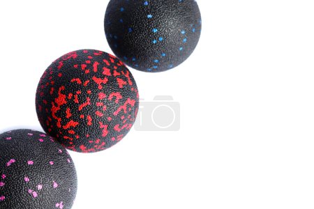 Three massage black balls with colorful spots for trigger points isolated on a white background. Concept of myofascial release.