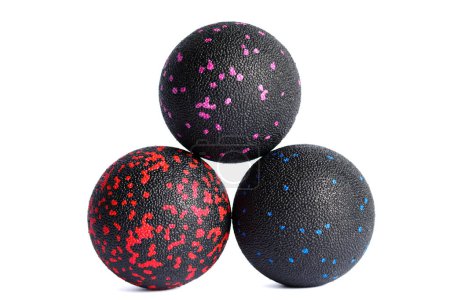 Tres bolas de masaje negro con manchas de colores para los puntos de disparo aislados sobre un fondo blanco. Concepto de liberación miofascial.