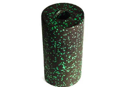 A black green massage foam roller isolated on a white background. Close-up. Foam rolling is a self myofascial release technique. Concept of fitness equipment.