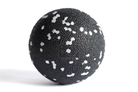 Masajear bola negra con manchas blancas para puntos de disparo aislados sobre un fondo blanco. Concepto de liberación miofascial.