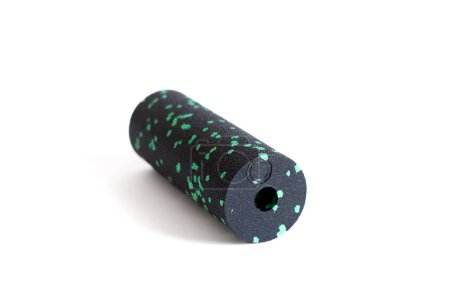 A black green massage foam roller mini isolated on a white background. Close-up. Foam rolling is a self myofascial release technique. Concept of fitness equipment.